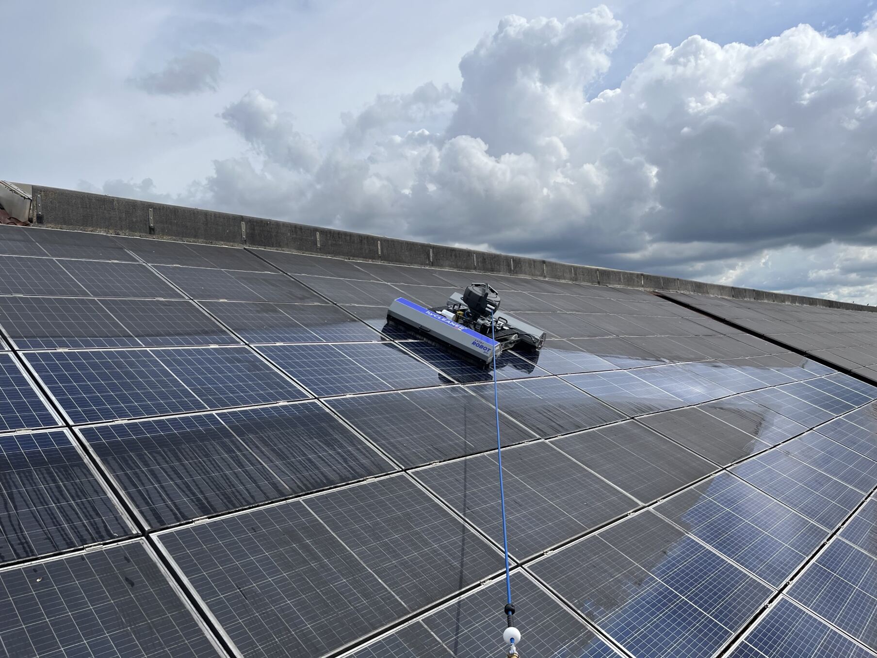 How often should solar panels be cleaned? A robot cleans a large solar surface, the differences between the cleaned and the dirty surface are clearly visible.