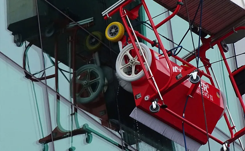 Reinigungsroboter facadeBRUSH v-line wird an einer Glasfassade positioniert